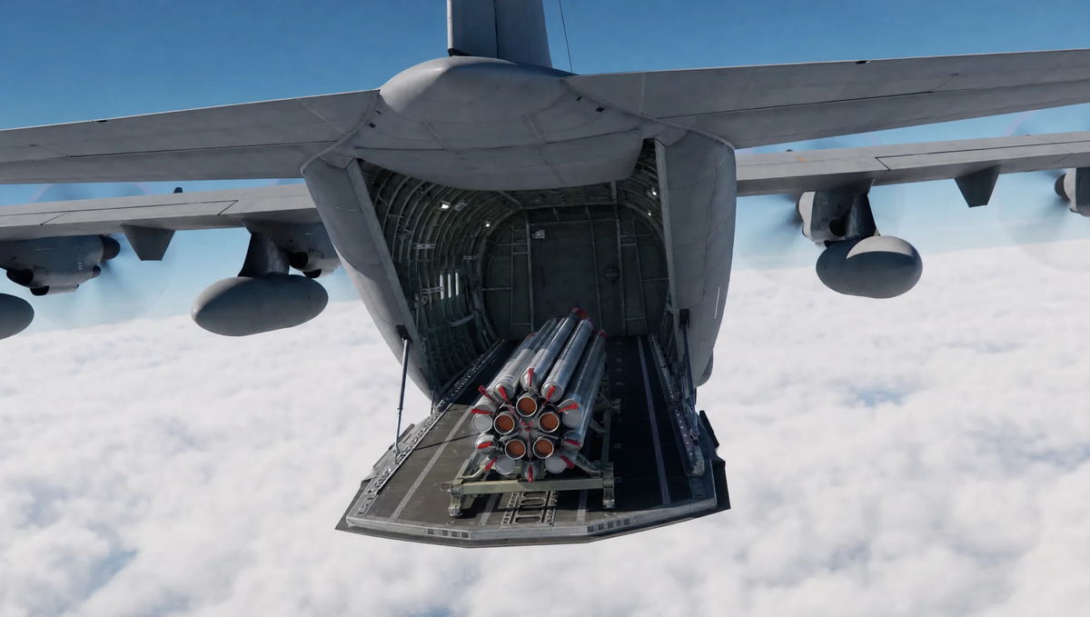 Bee-SL launch vehicle on a pallet at the open rear ramp of a military transport aircraft at altitude, above a cloud deck